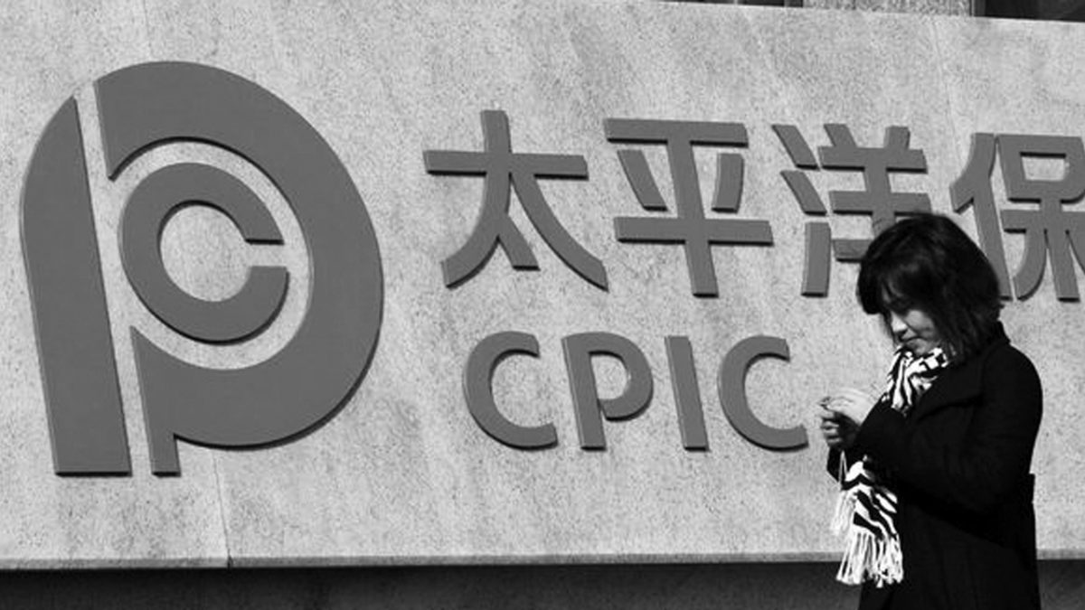 Woman walking past Chinese insurance firm CPIC