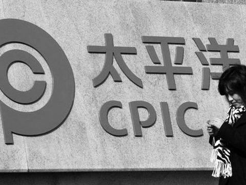 Woman walking past Chinese insurance firm CPIC