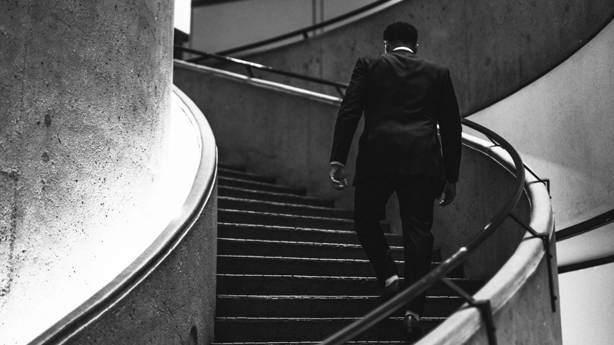 man in a suit going up the stairs