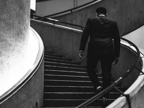 man in a suit going up the stairs